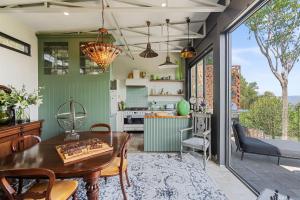 een keuken en eetkamer met een tafel bij Escape to Serenity in Beechmont Luxurious Cabin Retreat in Beechmont +13 foto's