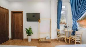 ein Zimmer mit Fernseher und Tisch und Stühlen in der Unterkunft May Trang Villa in Xuan An