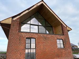 a large window on the side of a brick building at Tjusteplekske in Heuvelland +11 photos