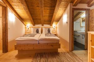フィーバーブルンにあるHaberlhütteの木製の天井の客室のベッド1台分です。