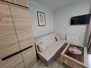 een kleine woonkamer met een bank en een tafel bij Wilczy Zakątek in Karpacz