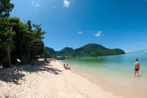 a group of people on a beach in the water at Voyagers Hostel in Phi Phi Islands