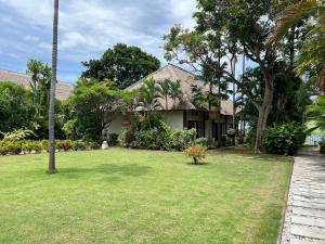 een huis met een gazon ervoor bij Beachfront Villa Mawar with Private Pool and Sunset View in Pengastulan