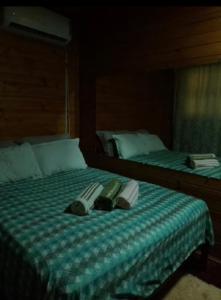 due letti con asciugamani e pantofole sopra di Cabanas paraíso pousadas a Bagé Altre 14 foto
