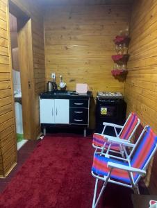 una cucina con 2 sedie e un piano cottura di Cabanas paraíso pousadas a Bagé