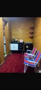 una stanza con due sedie e una cucina con bancone di Cabanas paraíso pousadas a Bagé