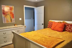 una camera da letto con un letto con cuscini arancioni e un comò di High Springs FL Hideaway a High Springs Altre 24 foto