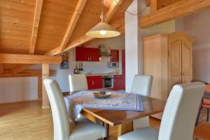 una cucina e una sala da pranzo con tavolo e sedie in legno di TraumWohnung a Seebruck
