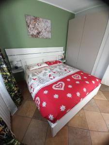 una camera da letto con un letto con una coperta rossa di Dimora degli Gnomi a Tirano Altre 10 foto