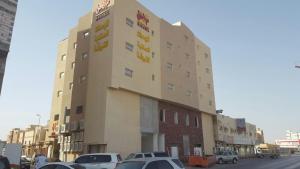 un grande edificio con macchine parcheggiate di fronte di مراحل للشقق المخدومة الخرج 2 ad Al Kharj