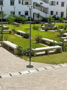 a park with benches in front of a building at Buxton Point Kandy Cozy Two Bedroom Apartment in Mombasa +8 photos
