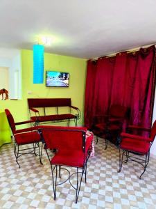 ein Zimmer mit roten Stühlen und Tischen und roten Vorhängen in der Unterkunft Dar Jana Tozeur in Tozeur
