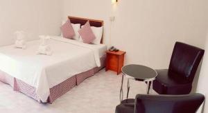 ein Schlafzimmer mit zwei Betten und einem Tisch und einem Stuhl in der Unterkunft Hotel De Ratt Phuket in Ban Laem Hin