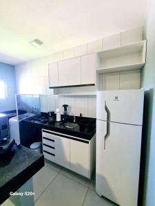 a kitchen with white cabinets and a white refrigerator at Brisa & Mar do Preá-700 m da praia e 12 km de Jeri in Jericoacoara