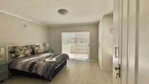 a bedroom with a large bed and a window at Maison Dauphine in Cape Town