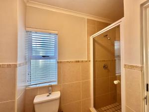 a bathroom with a toilet and a shower with a window at Maison Dauphine in Cape Town +23 photos