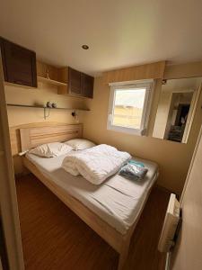 Cama pequeña en habitación pequeña con ventana en La Lessinoise - Park Costa Bredene, en Bredene