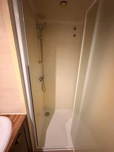 un baño con cabina de ducha junto a un lavabo en La Lessinoise - Park Costa Bredene, en Bredene