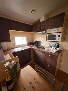 Una pequeña cocina con estufa y microondas. en La Lessinoise - Park Costa Bredene, en Bredene 8 fotos más