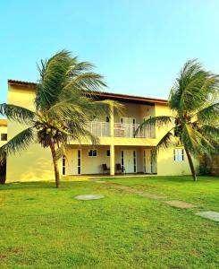 a building with two palm trees in front of it at Brisa & Mar do Preá-700 m da praia e 12 km de Jeri in Jericoacoara