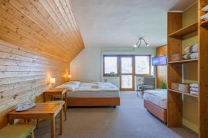 una stanza con due letti e un tavolo in una stanza di Hotel Rusava a Rusava