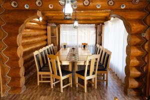 una sala da pranzo con tavolo e sedie in legno di Mocearu Retreat 