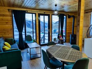 a living room with a table and chairs and mountains at Ushguli Highland Cottage in Ushguli