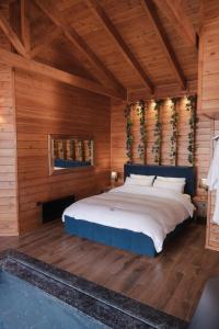 una camera da letto con un grande letto e pareti in legno di Cave Chalet - Chalet for Two a Eptalofos Altre 17 foto