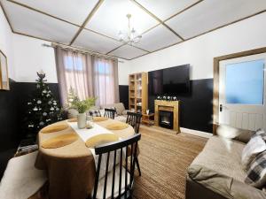 een woonkamer met een tafel en een kerstboom bij The Trackside Cottage in Carlin How