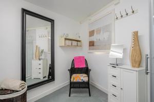 een kleedkamer met een spiegel en een stoel bij Keralia in Wivenhoe +15 foto's