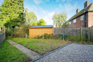 een achtertuin met een hek en een houten schuur bij Keralia in Wivenhoe