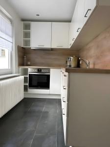 eine Küche mit weißen Schränken und einer Spüle in der Unterkunft Ferienwohnung Donauherz in Stetten