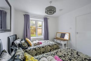 een hotelkamer met twee bedden en een raam bij Keralia in Wivenhoe