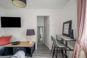 een woonkamer met een bank, een tafel en een bureau bij Keralia in Wivenhoe