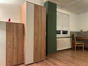 ein Zimmer mit Holzschränken und einem Tisch und einem Stuhl in der Unterkunft Ferienwohnung Donauherz in Stetten + 5 Fotos