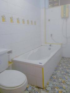 ein Badezimmer mit einer weißen Badewanne und einem WC in der Unterkunft Sairung Farmstay and Cawboy Krabi in Ban Nua Khlong