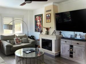 een woonkamer met een bank en een open haard bij Villa Flor de Neu in Denia