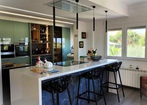 een keuken met een groot eiland met barkrukken bij Villa Flor de Neu in Denia