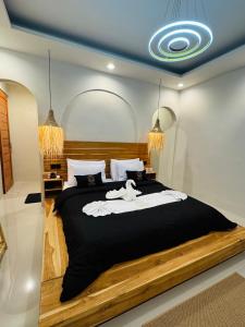 a bedroom with a large bed with black and white sheets at Pinggan Tavora in Gretek