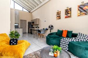 een woonkamer met een groene bank en een tafel bij Retro Pop FREE Parking Fast Wifi Pool Large Workspace in Sandton