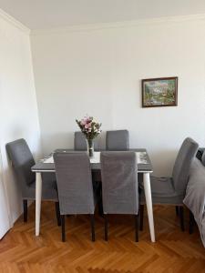 une table à manger avec des chaises et un vase de fleurs. dans l'établissement Bar Central Stay Apartment, à Bar