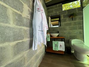 une salle de bain avec une serviette accrochée à un mur de briques dans l'établissement Cabañas Ecoturísticas Villa Beatrice, à Estación El Salto
