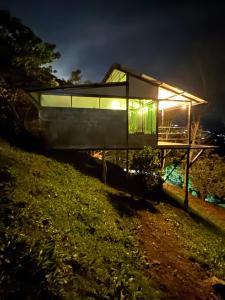 une maison de verre sur une colline la nuit dans l'établissement Cabañas Ecoturísticas Villa Beatrice, à Estación El Salto