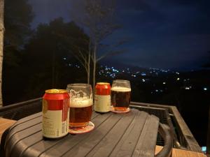 trois verres de bière assis sur une table en bois dans l'établissement Cabañas Ecoturísticas Villa Beatrice, à Estación El Salto