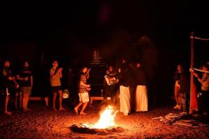 a group of people standing around a fire at Magic land taba camp in Taba