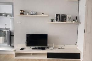 a television sitting on a desk in a living room at studio room dami in Kathu