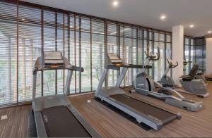 a gym with three tread machines in a room with windows at studio room dami in Kathu