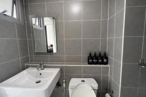 a bathroom with a sink and a toilet and a mirror at studio room dami in Kathu