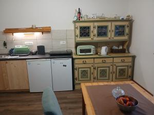 a kitchen with wooden cabinets and a bowl of fruit on a table at Kod bake in Oštarije