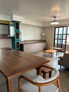 a large living room with a wooden table and chairs at Apartamento Outeiro in Ilhéus